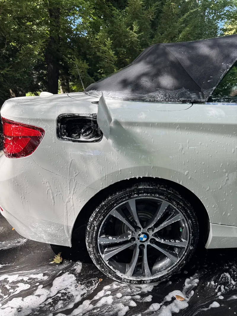 White BMW covered in foam during a hand wash