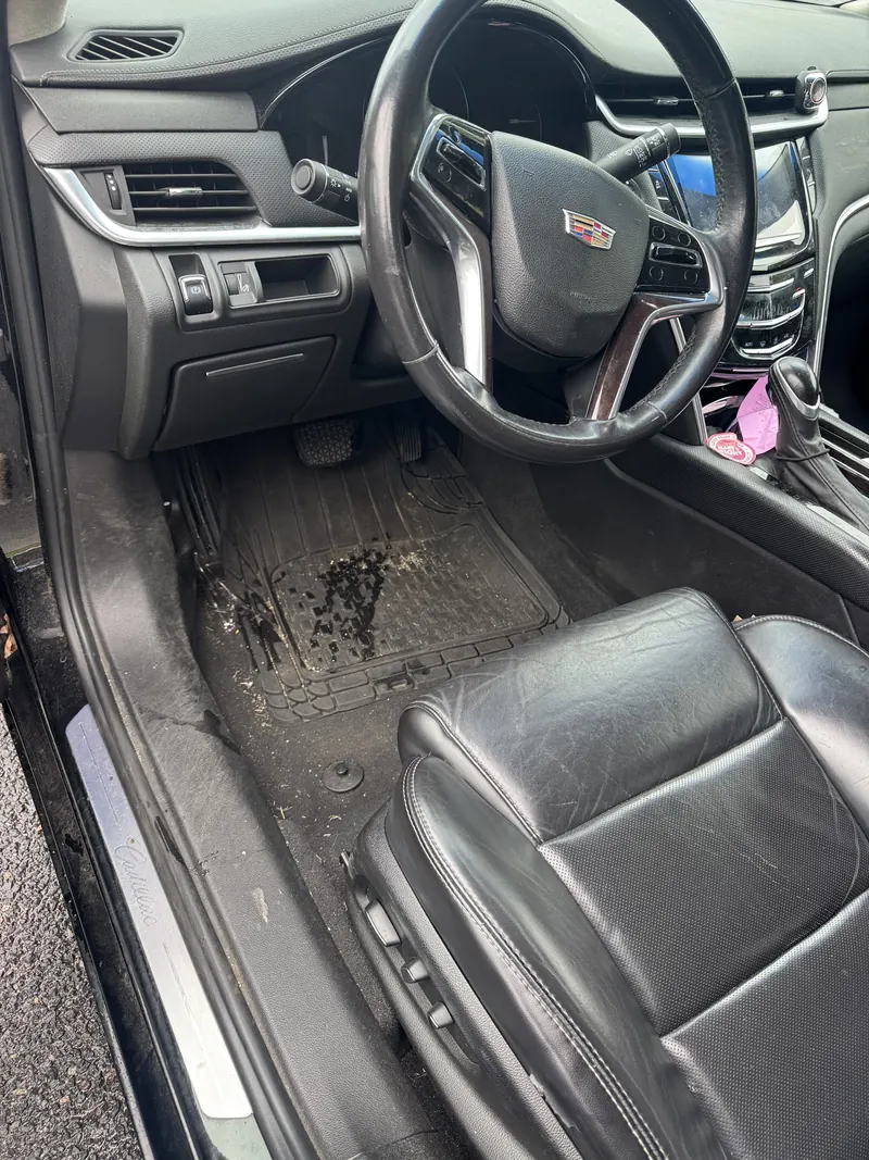 Before: Cadillac footwell with a muddy, stained floor mat